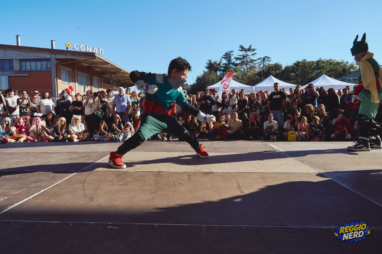 Cosplay di Deku sul palco davanti a una folla di spettatori